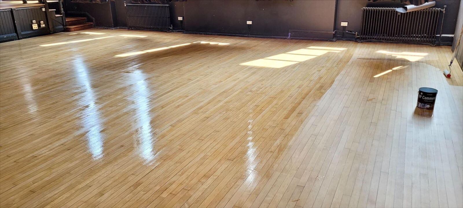 Commercial Oiling in Kent – freshly oiled maple hardwood floor in a commercial interior, showing half-finished treatment with a glossy protective finish.