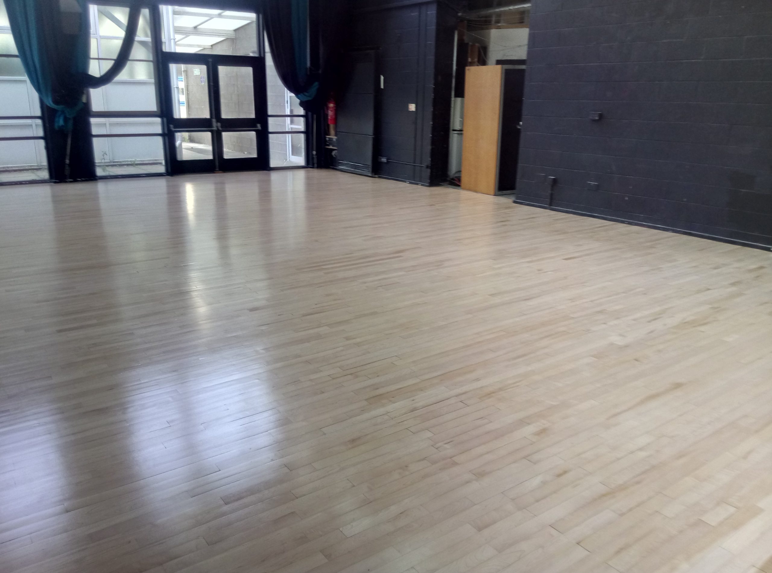 Smooth sanded wooden school hall floor in Kent with natural light and clean polished surface